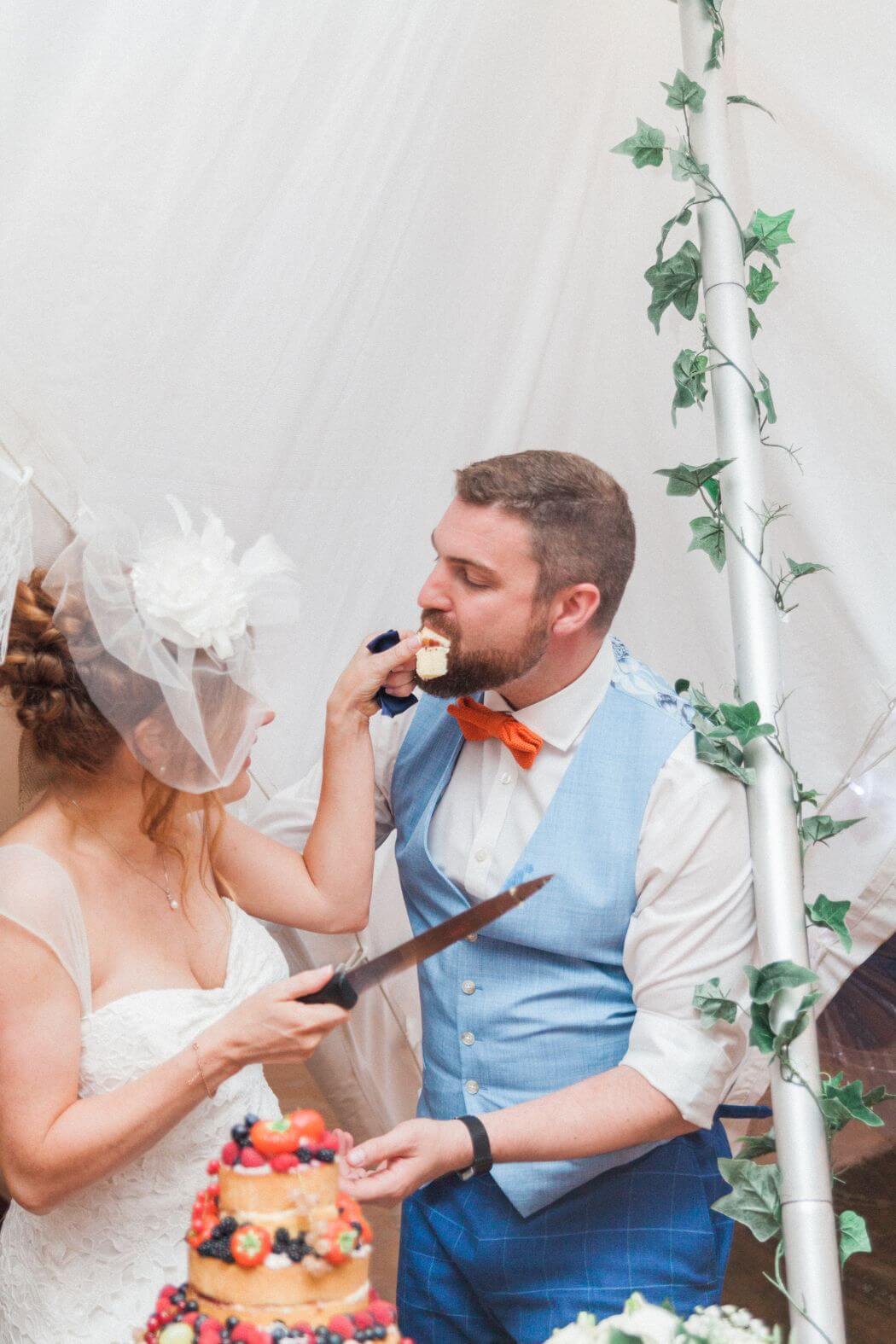 Bride feeding the groom a piece of wedding cake