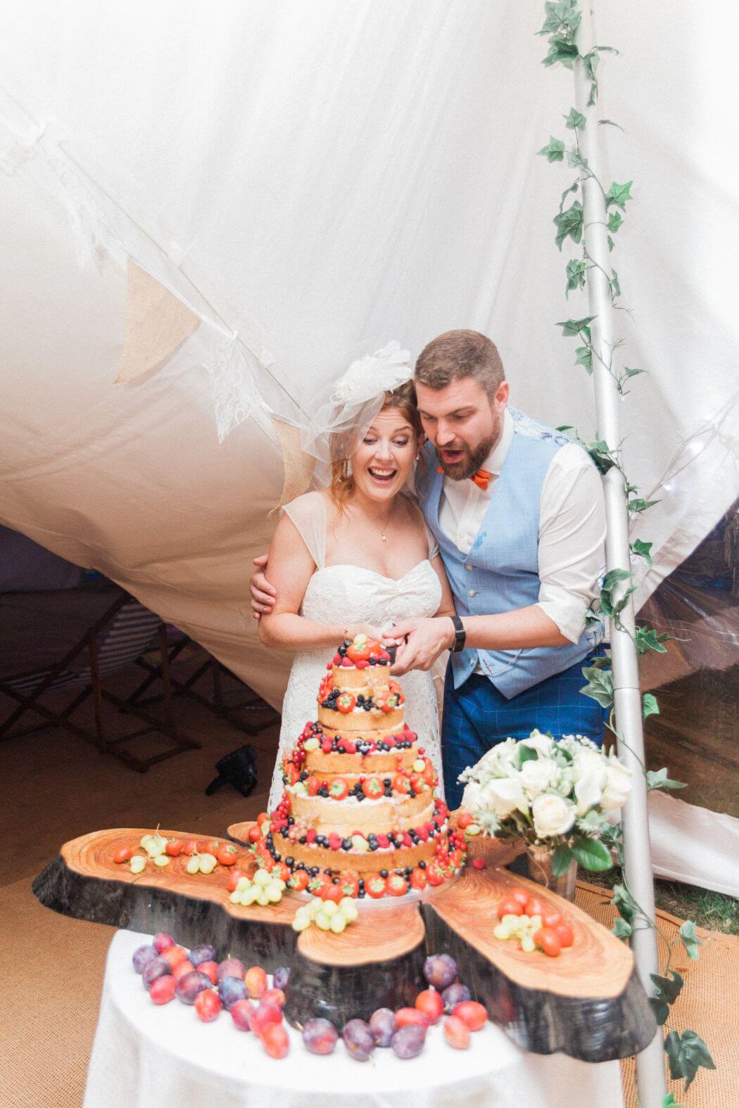 Bride and groom cutting the wedding cake together