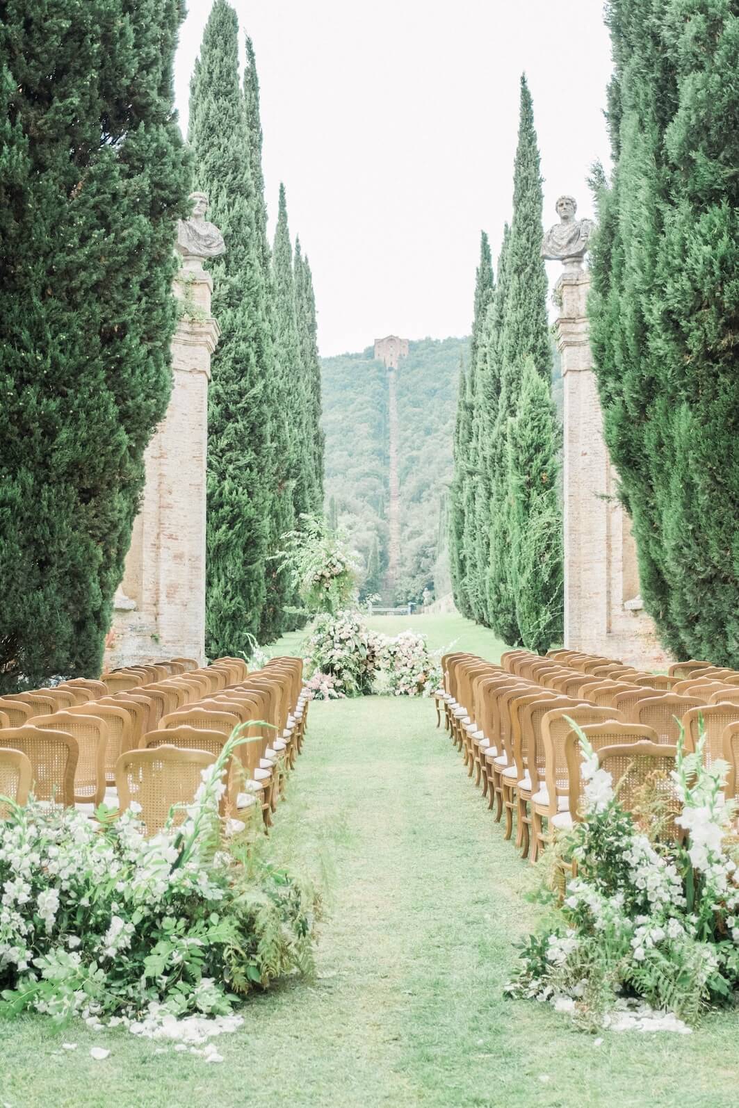 Tuscany wedding ceremony grounds with trees and chairs