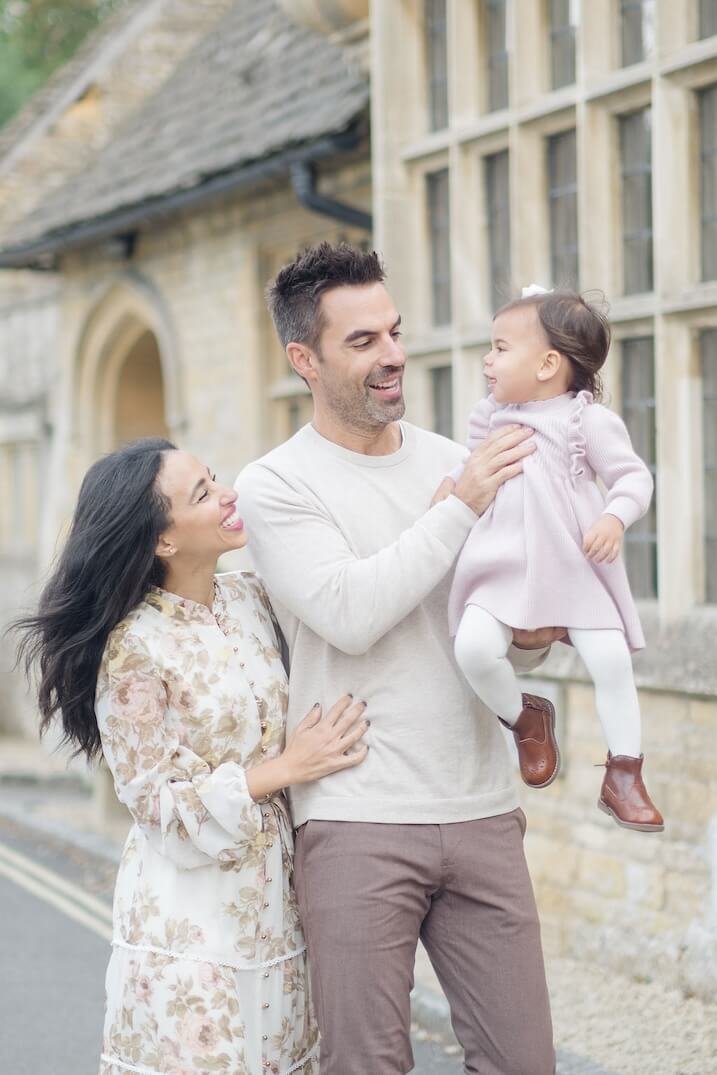 Family laughing together during a relaxed Cotswolds photo session