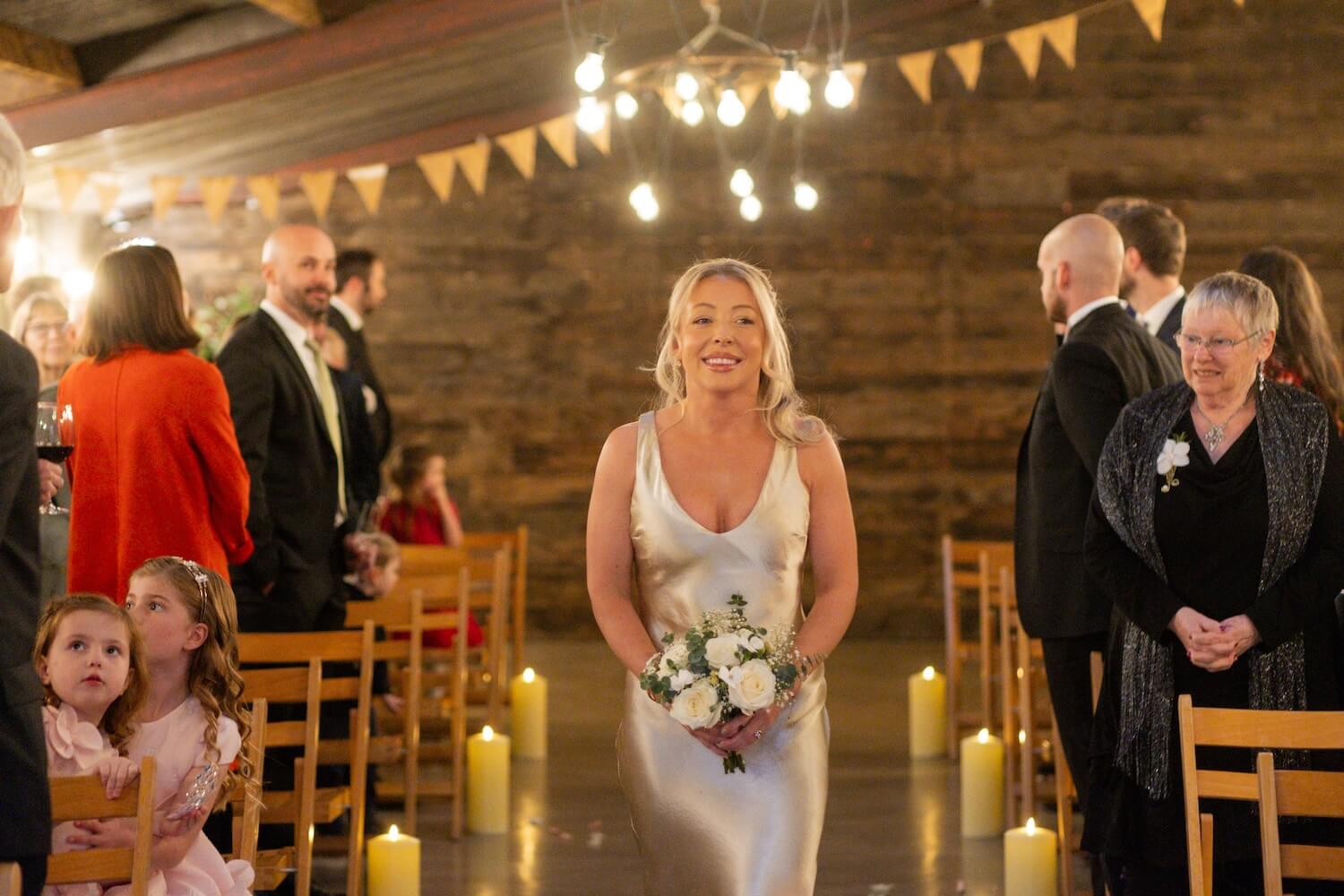 Bridesmaid walking down the aisle at Grange Wedding Barn Cheshire