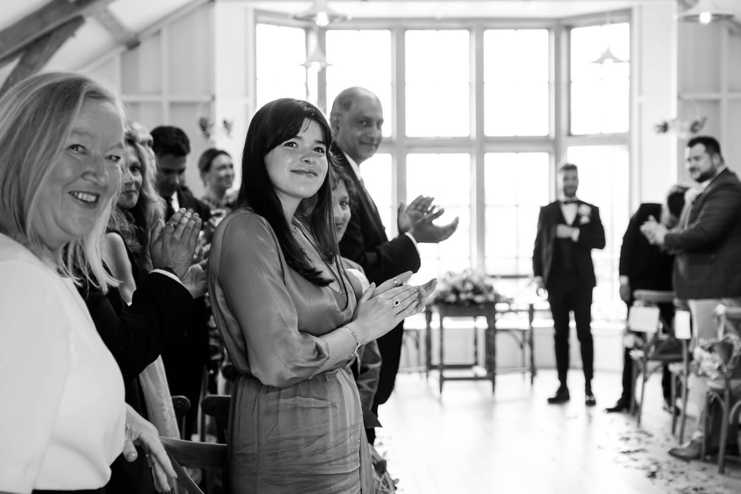 Guests clapping the bride and groom out of the ceremony at Hyde House