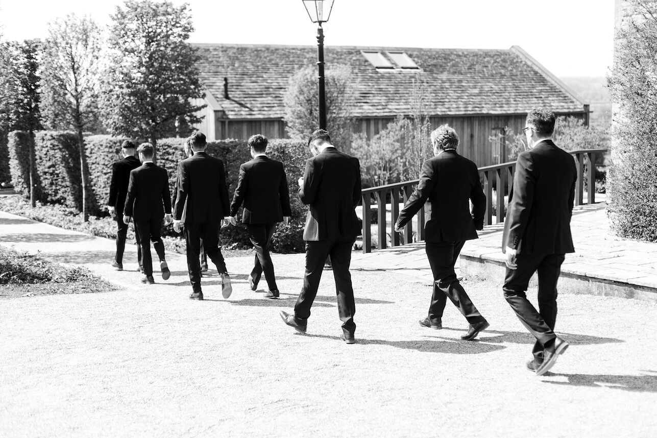 Groomsmen walking towards the ceremony barn at Hyde House