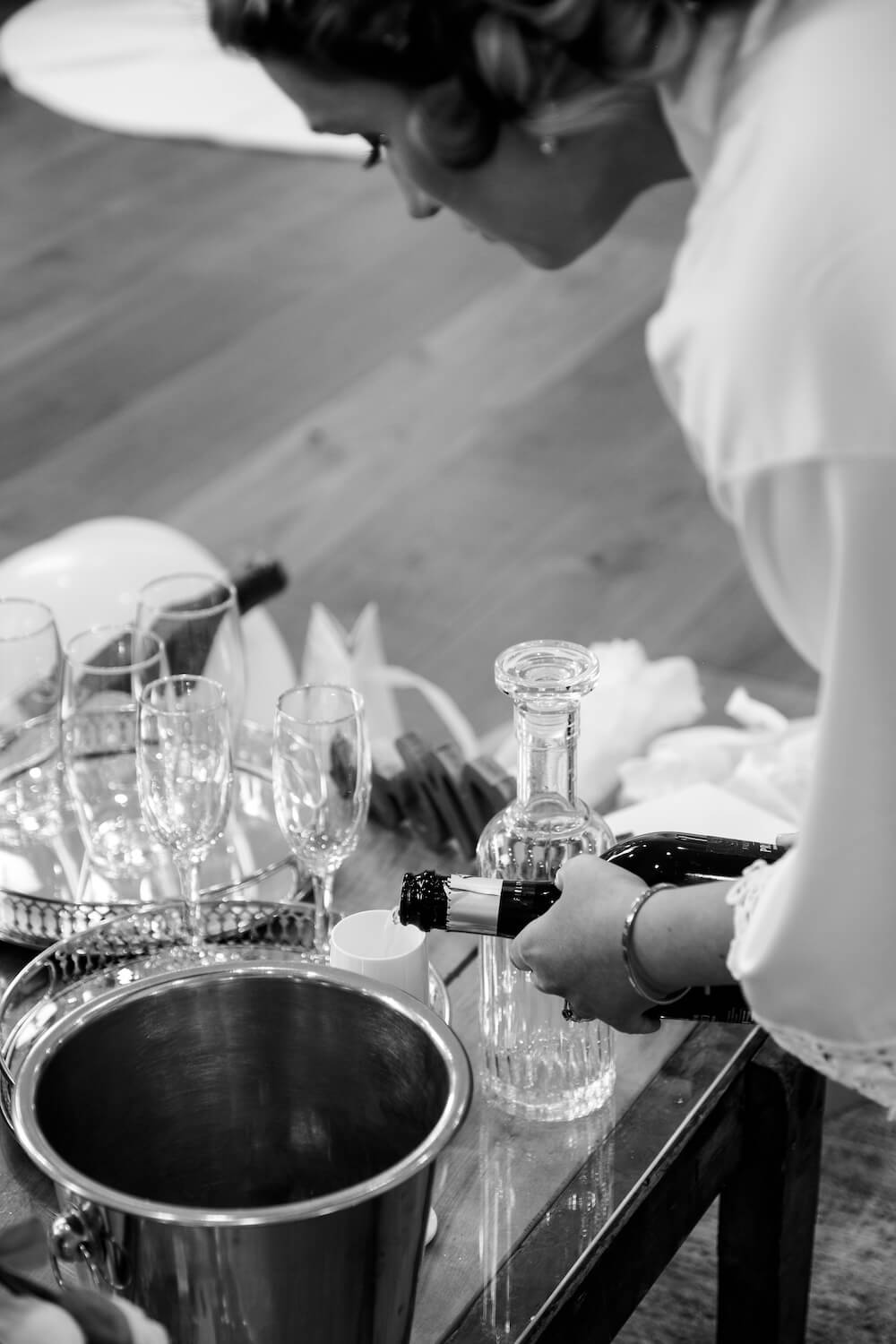 Bridesmaid pouring champagne during bridal preparations at Hyde House