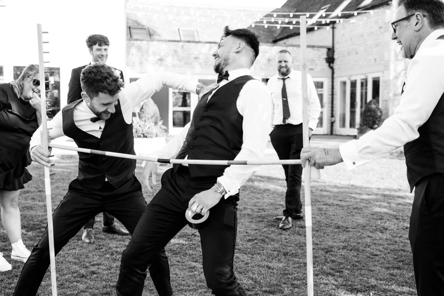 Groomsmen playing limbo at the evening reception at Hyde House