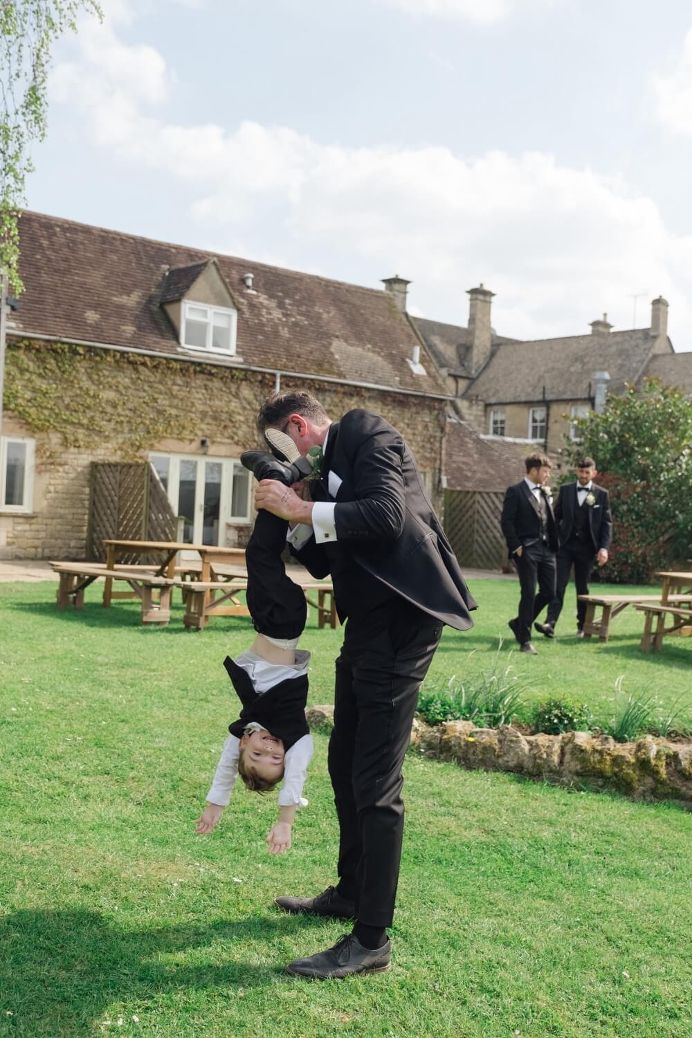 A guest holding the young son upside down at Hyde House