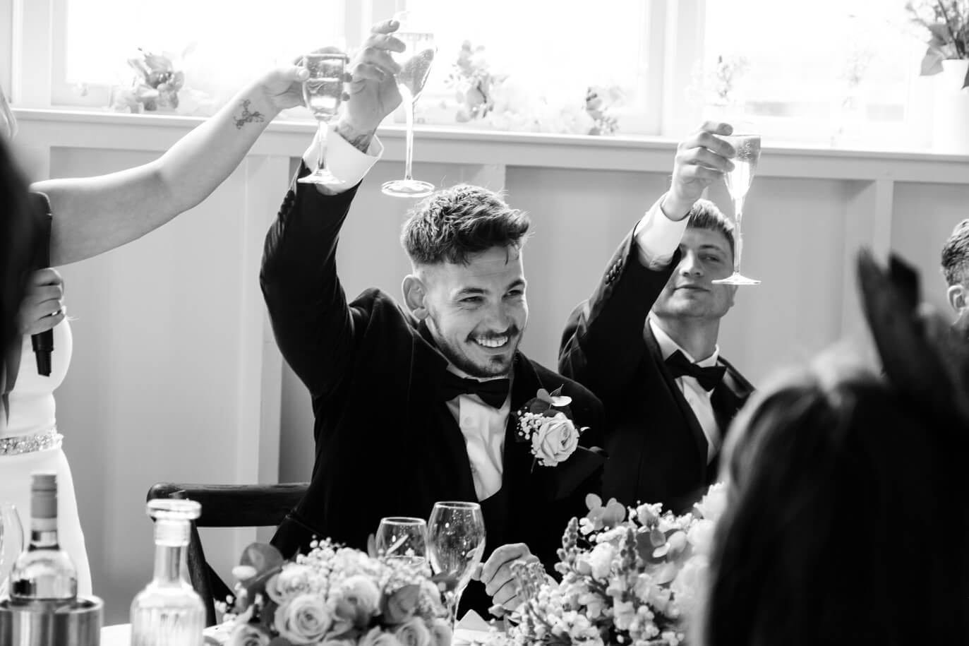 Groom smiling with champagne at Hyde House
