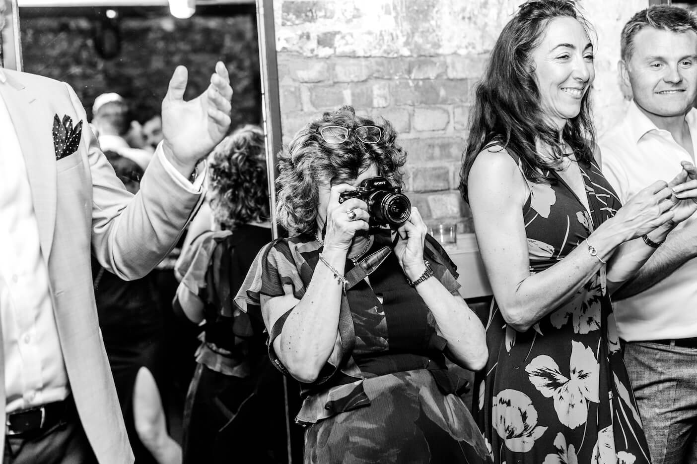 A guest taking photos on the dance floor, London city micro wedding