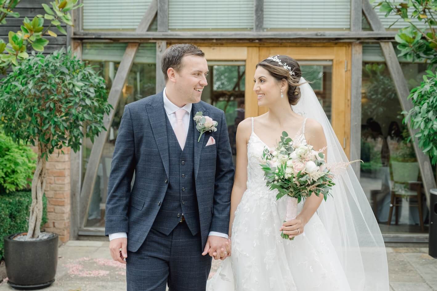 Bride and groom walking at Mythe Barn