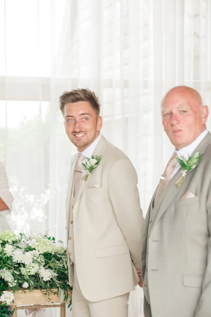 Groom smiling during the ceremony at Stratton Court Barn