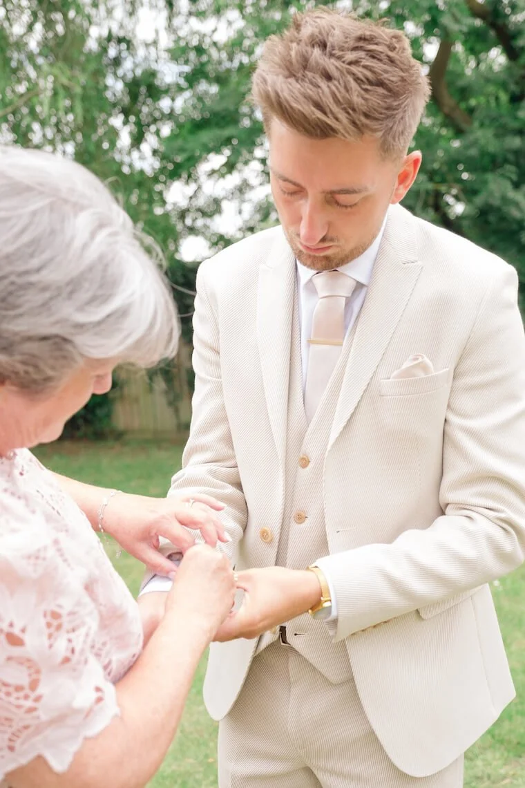 Groom fastening his cufflinks at Stratton Court Barn