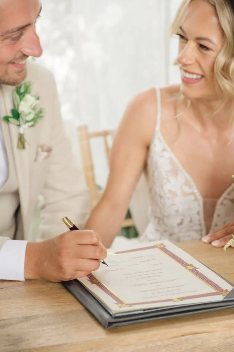 Bride and groom signing the register at Stratton Court Barn