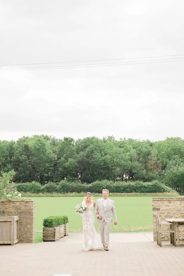 Bride and her father walking towards the ceremony at Stratton Court Barn