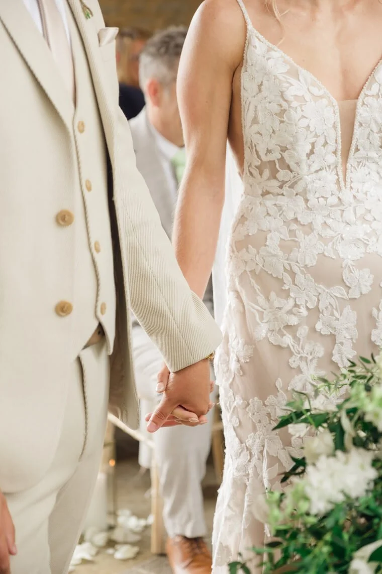 Bride and groom holding hands at Stratton Court Barn