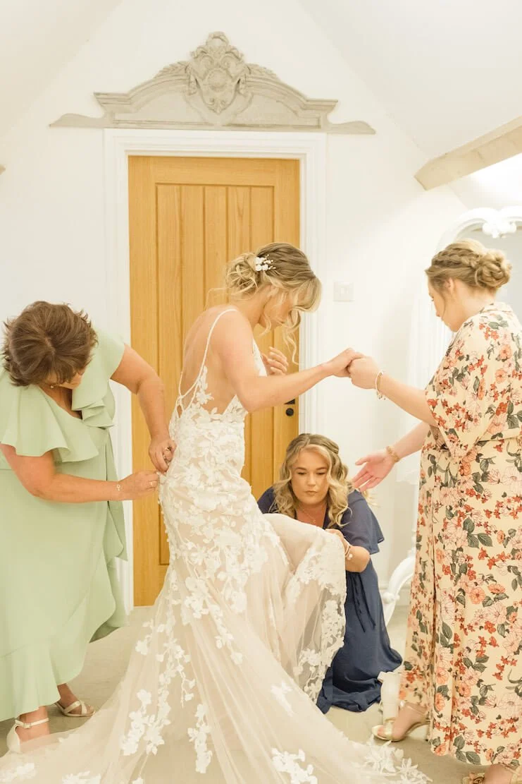 Bride being helped into her dress at Stratton Court Barn
