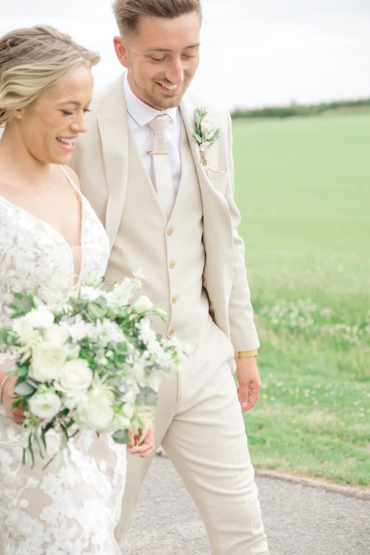 Bride and groom walking in the rose garden at Stratton Court Barn
