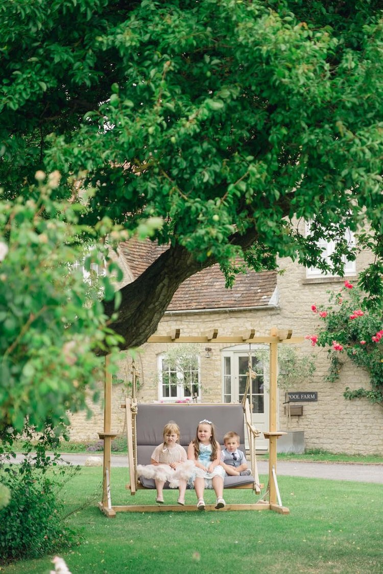 Children on the garden swing at Stratton Court Barn