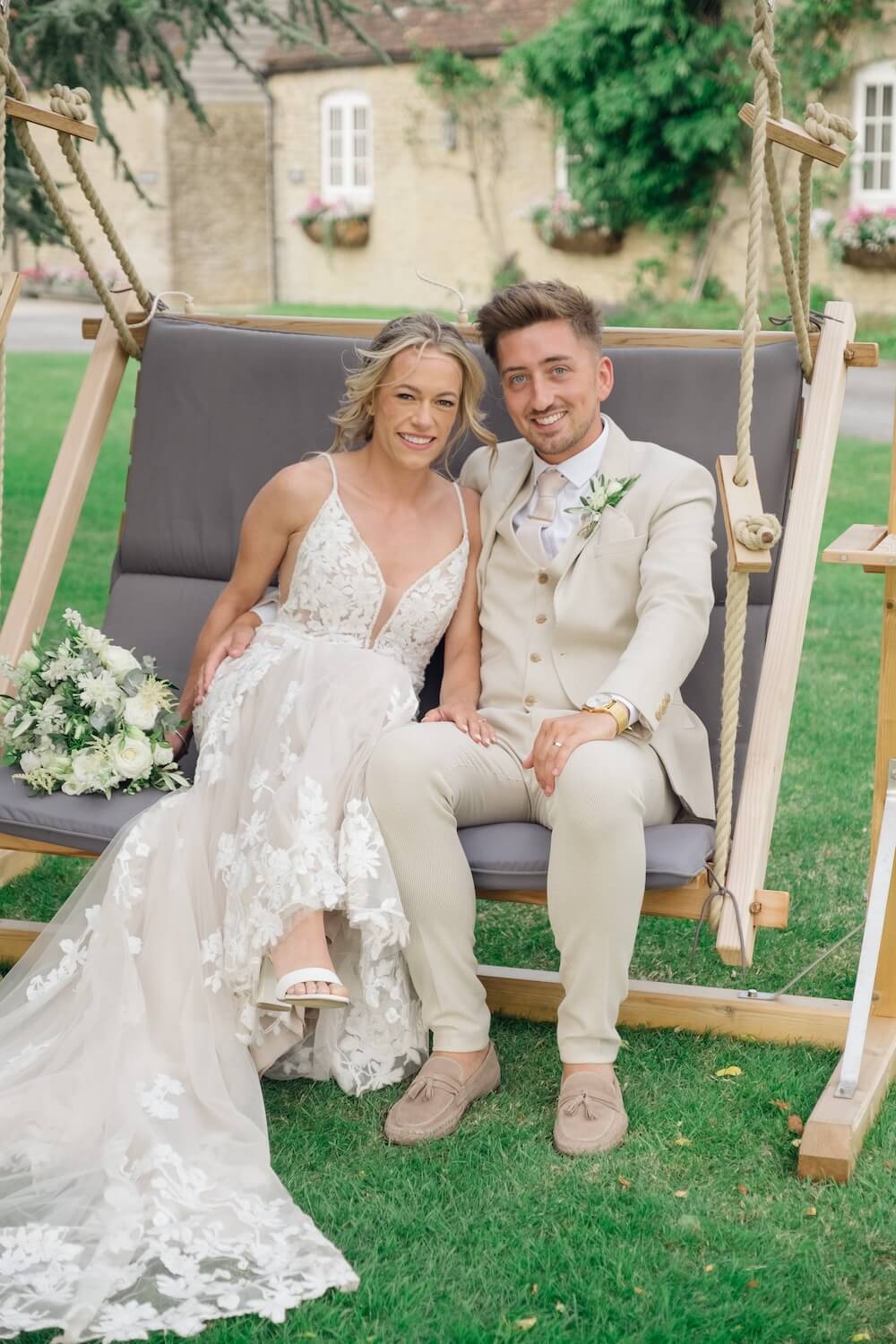 Bride and groom on the garden swing at Stratton Court Barn