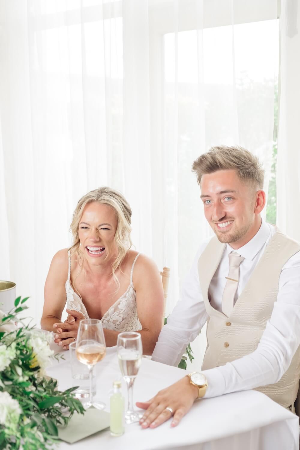 Bride and groom laughing during speeches at Stratton Court Barn