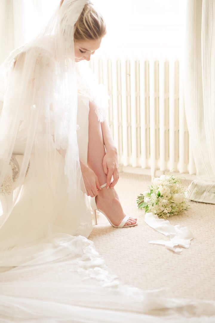 Bride putting on her wedding shoes