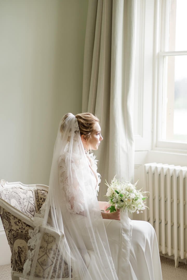 Bride sitting facing the window in the bridal suite