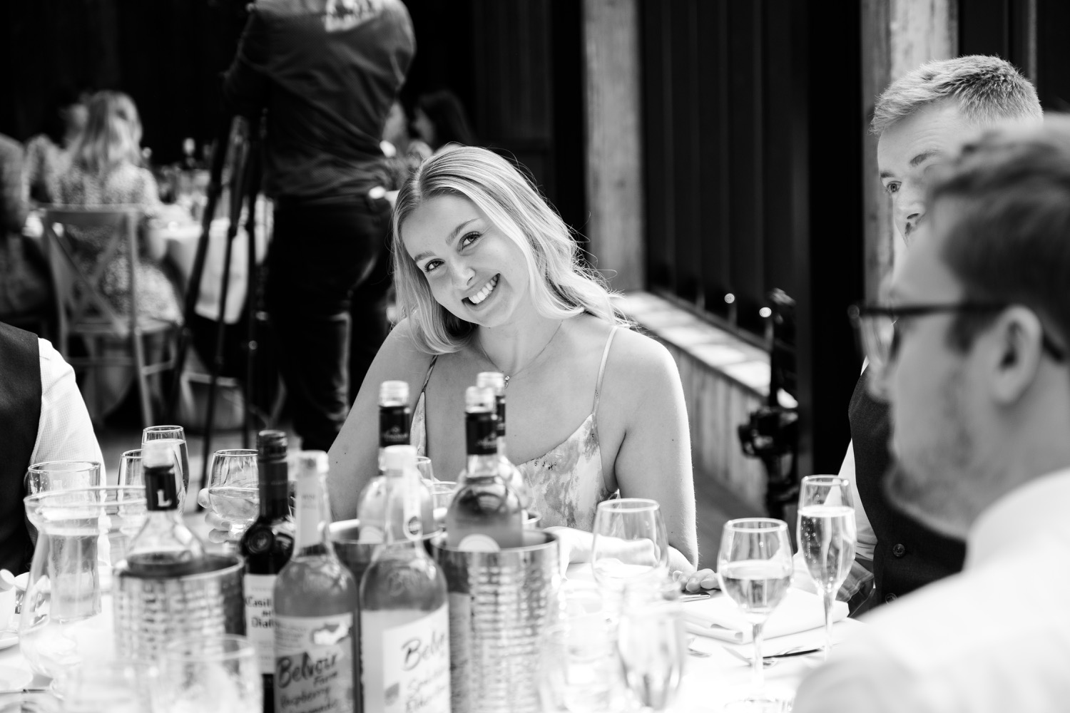 Guest posing at the table during the wedding breakfast at Foxtail Barns