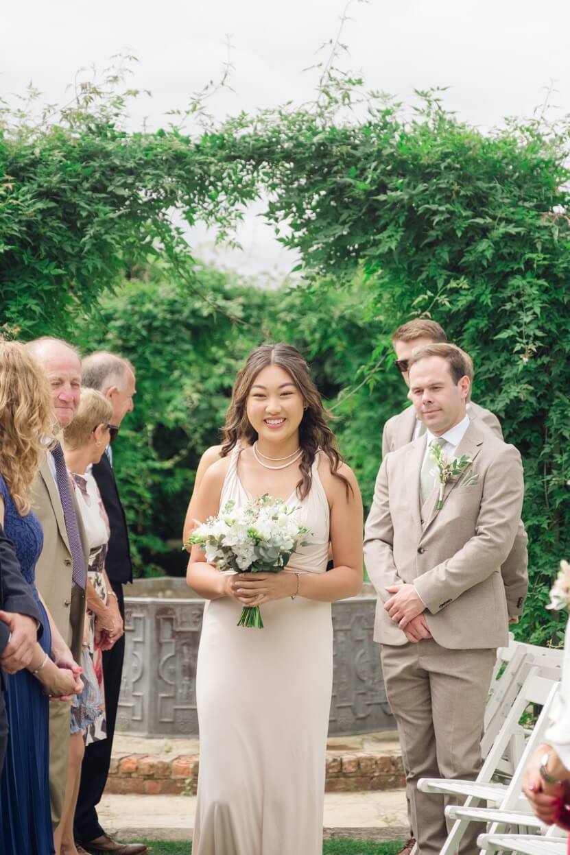 Bridesmaid walking down the aisle at Birtsmorton Court