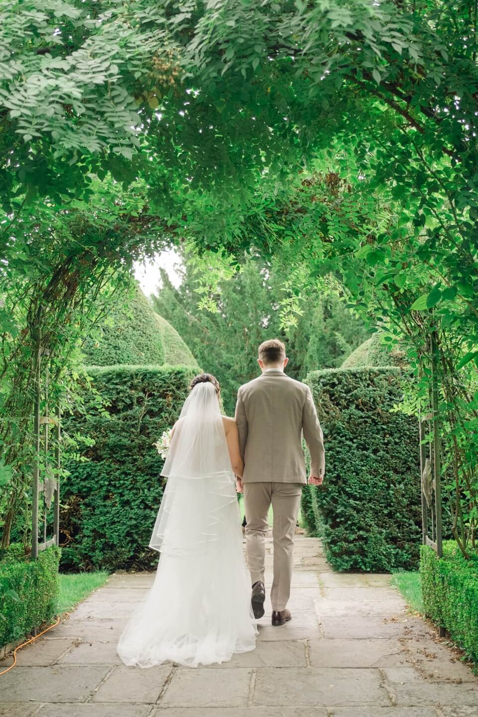 Newlyweds walking away from their White Garden ceremony at Birtsmorton Court