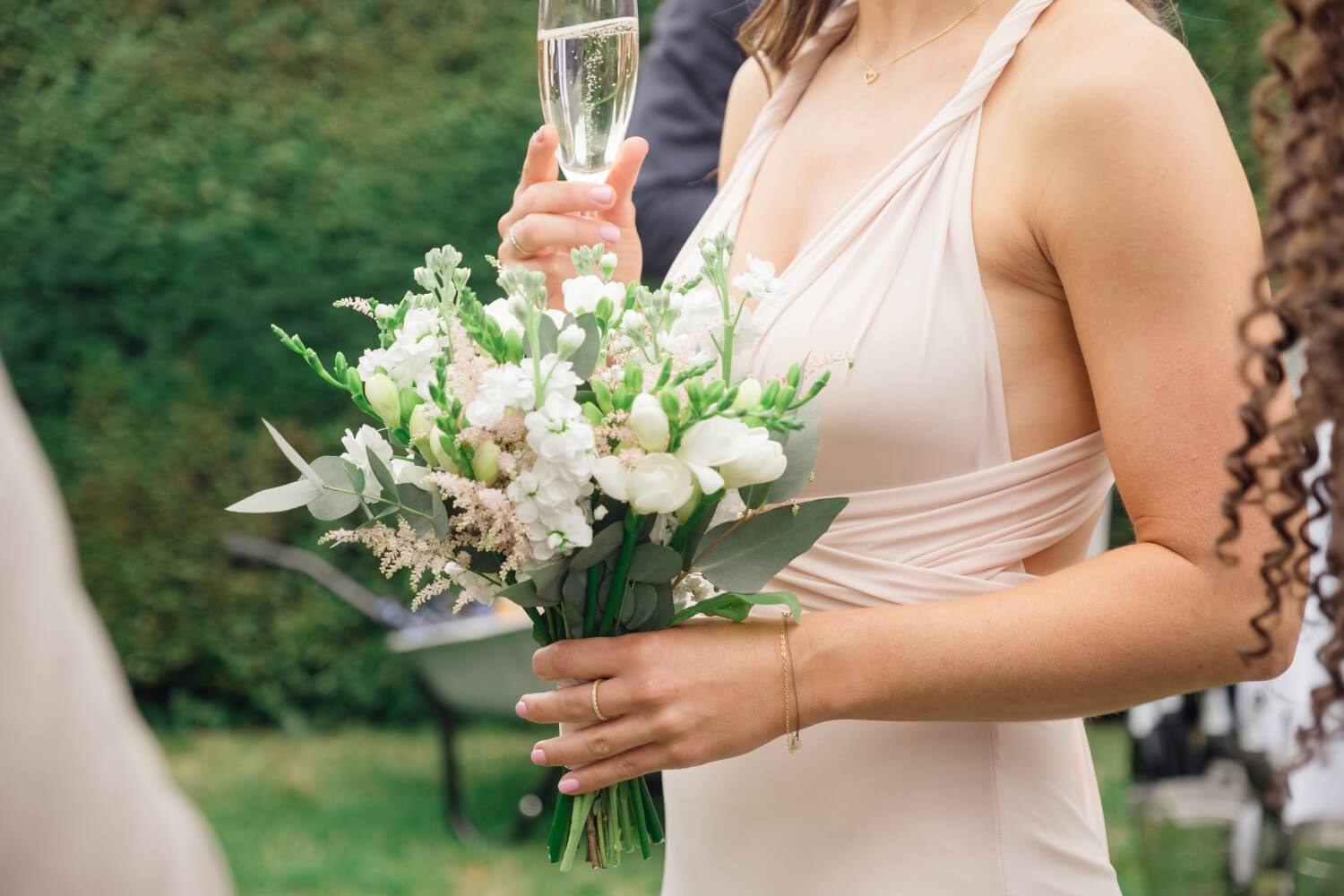 Bridesmaid with a glass of champagne at Birtsmorton Court