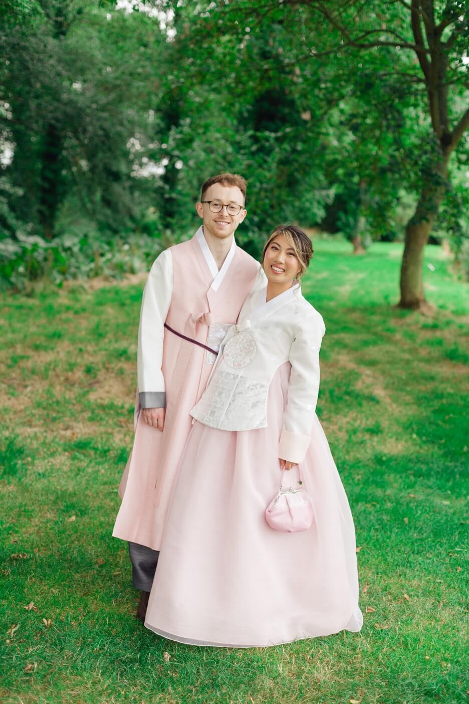 Bride and groom in matching hanbok, traditional Korean attire, at Birtsmorton Court