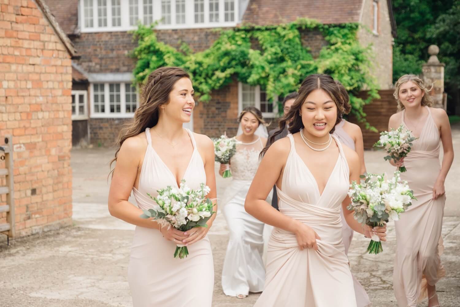Bride and bridesmaids walking to the White Garden ceremony at Birtsmorton Court
