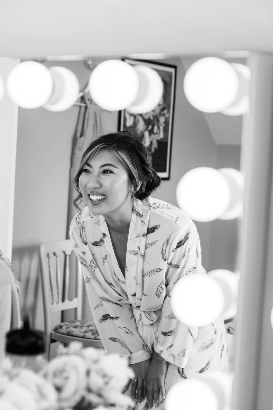 Bride looking in the mirror during bridal preparations at Birtsmorton Court