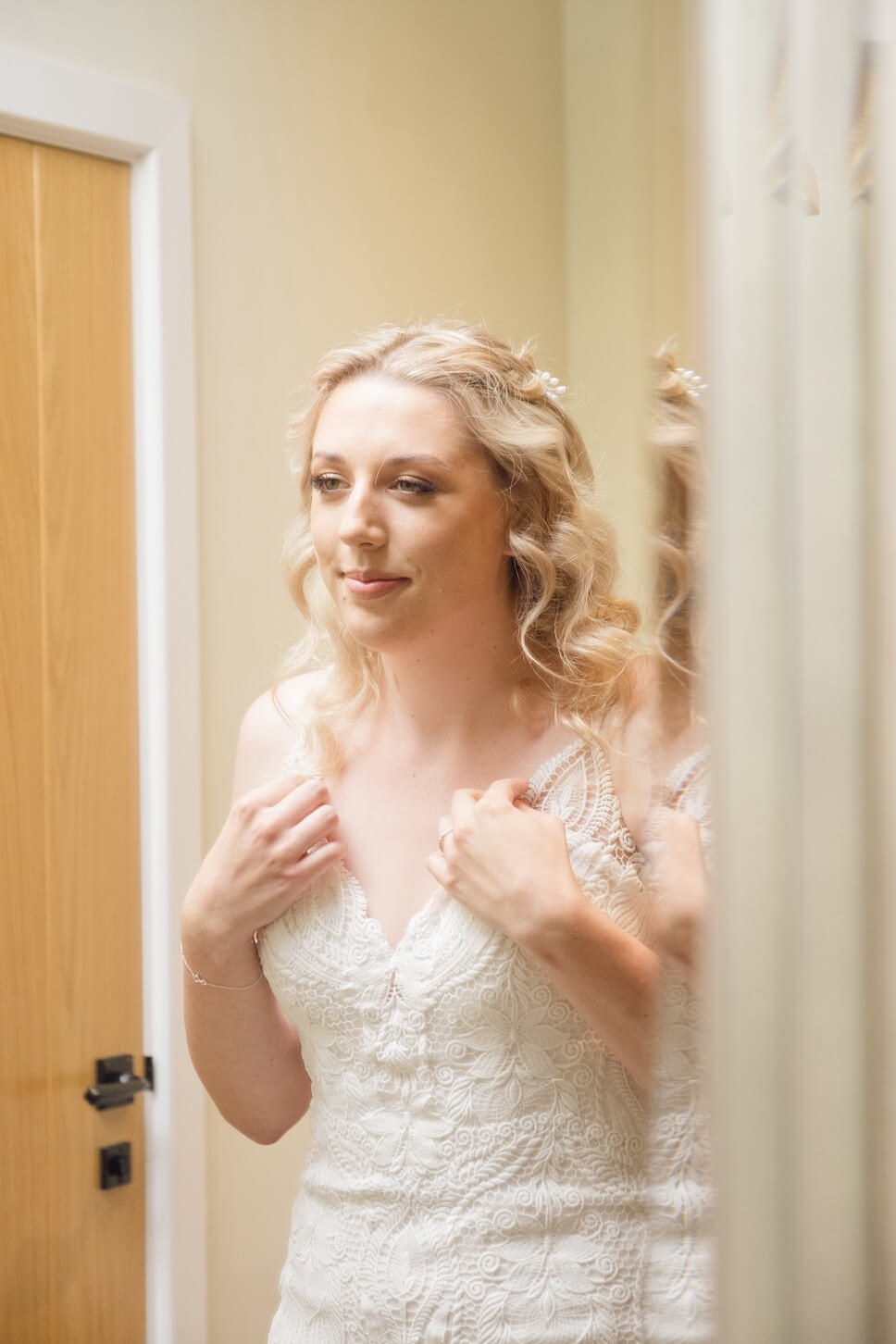 Bride looking in the mirror before her Foxtail Barns wedding