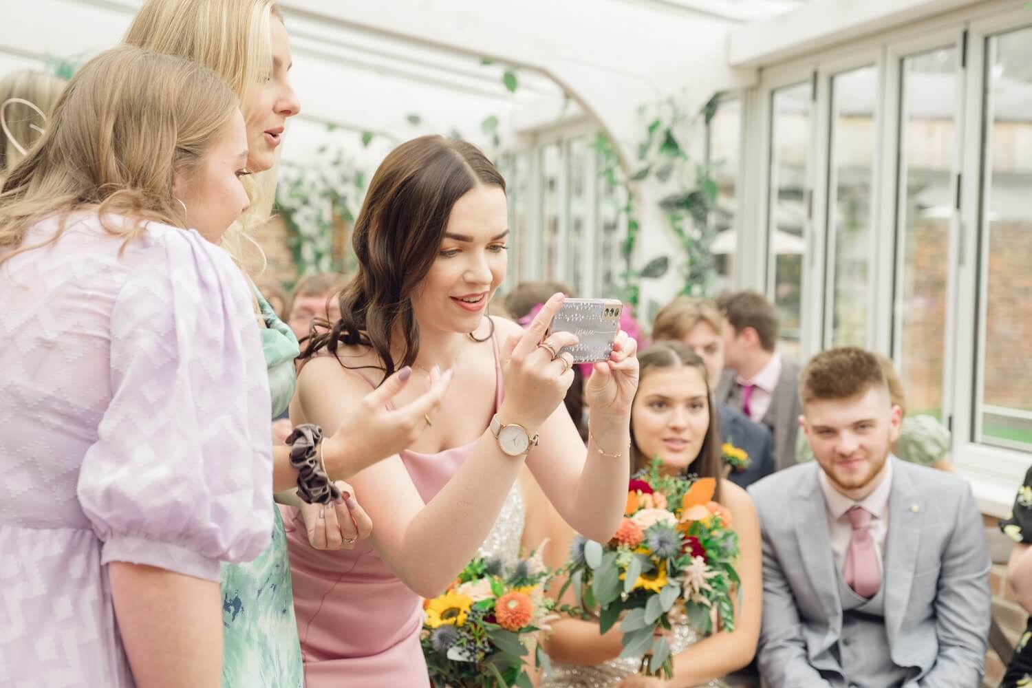 Guests taking photos during the ceremony at Foxtail Barns