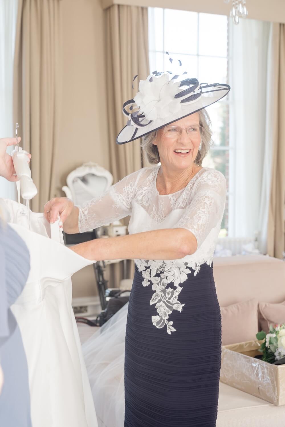 Mother of the bride helping with the dress at Hawkstone Hall