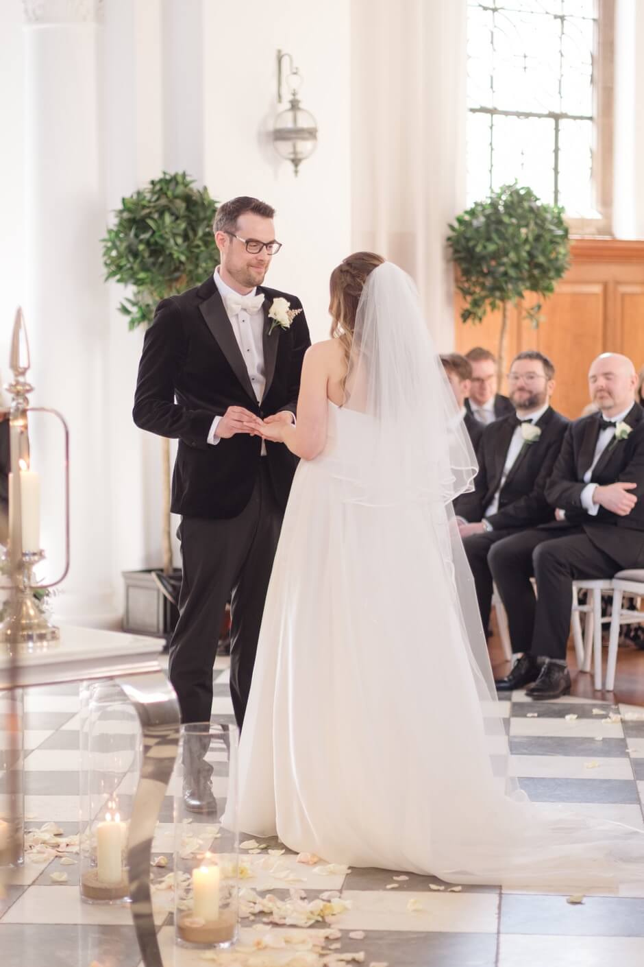 Groom putting the ring on the bride's finger at Hawkstone Hall