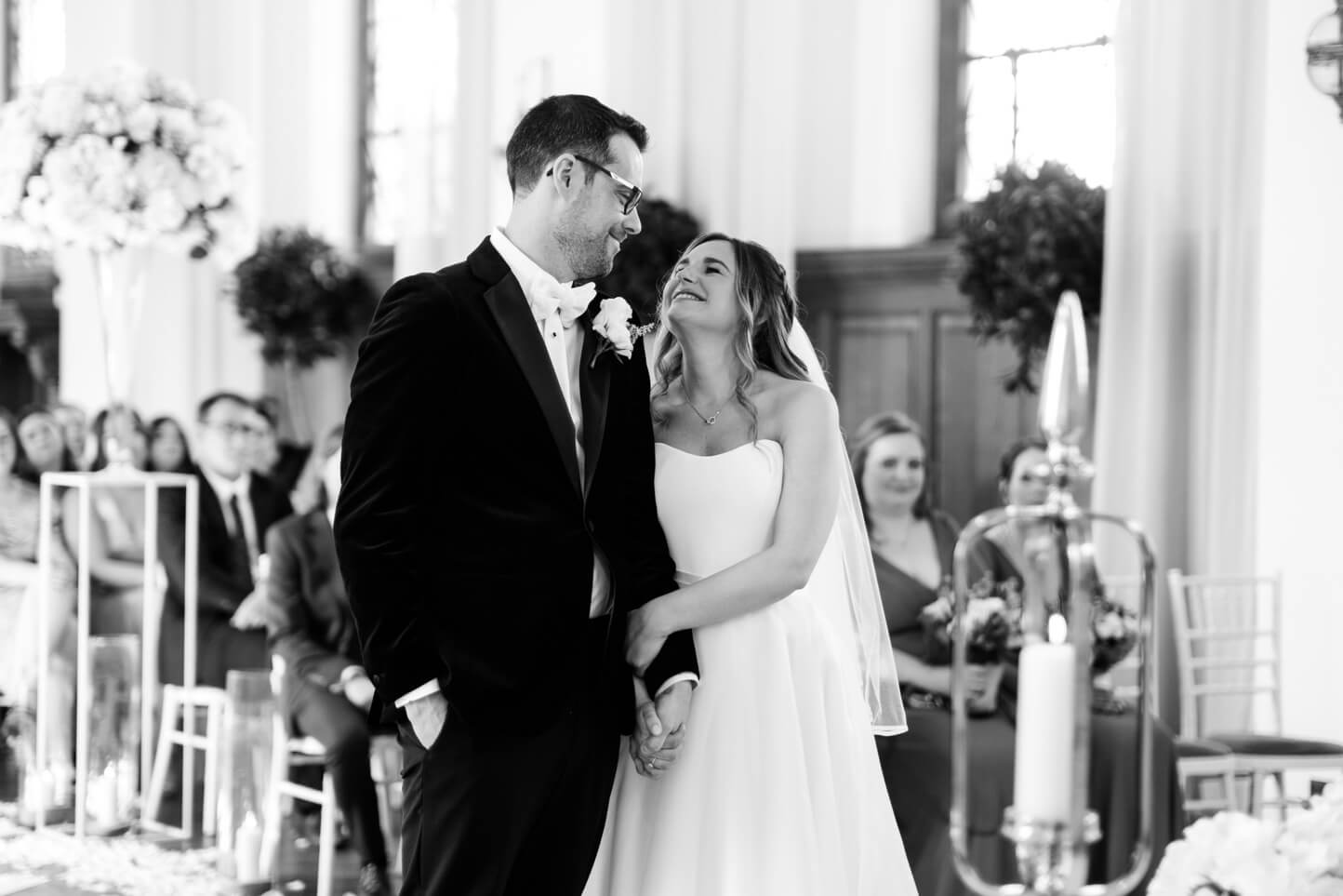 Bride and groom holding hands during the ceremony at Hawkstone Hall