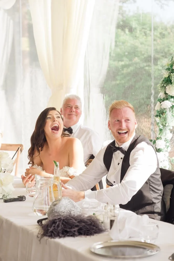 Bride and groom laughing during the speeches