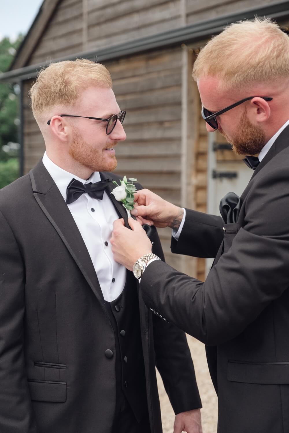 Groom having his buttonhole pinned on