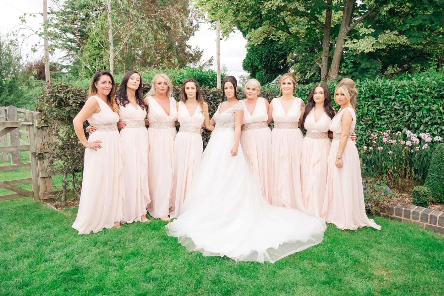 Bride with her bridesmaids in the gardens at Redhouse Barn