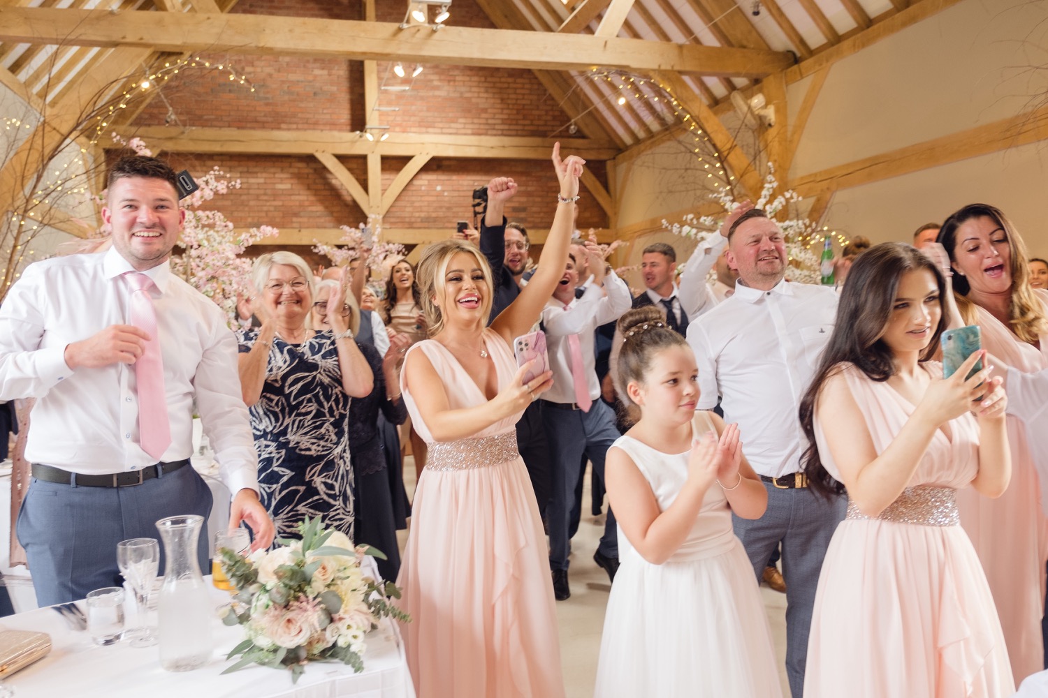 Guests on their feet as the newlyweds make their entrance at Redhouse Barn
