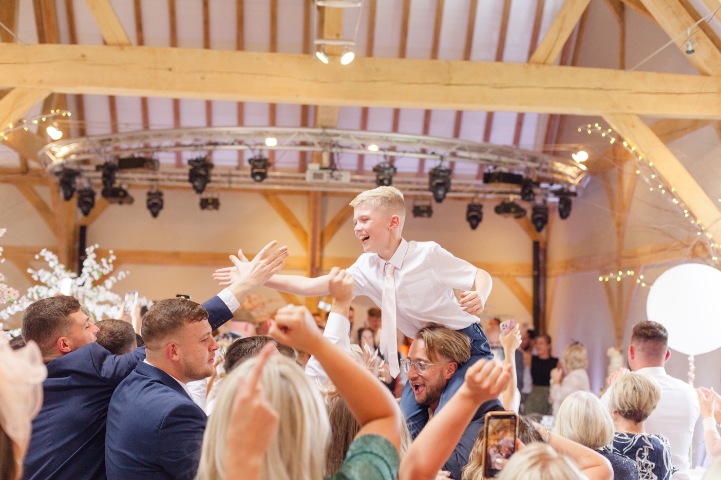 Child on shoulders celebrating at the Redhouse Barn wedding