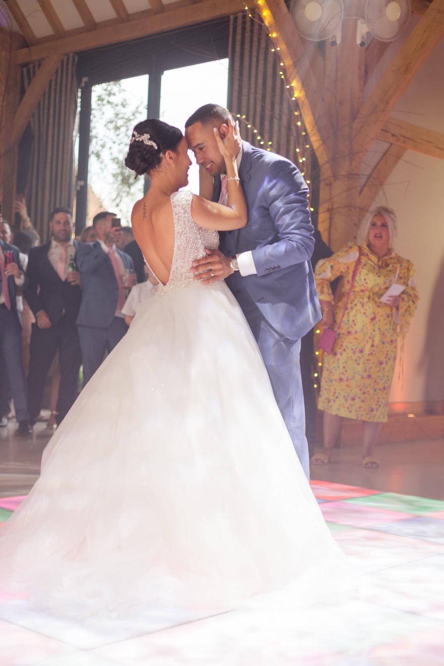 Newlyweds holding each other close during the first dance