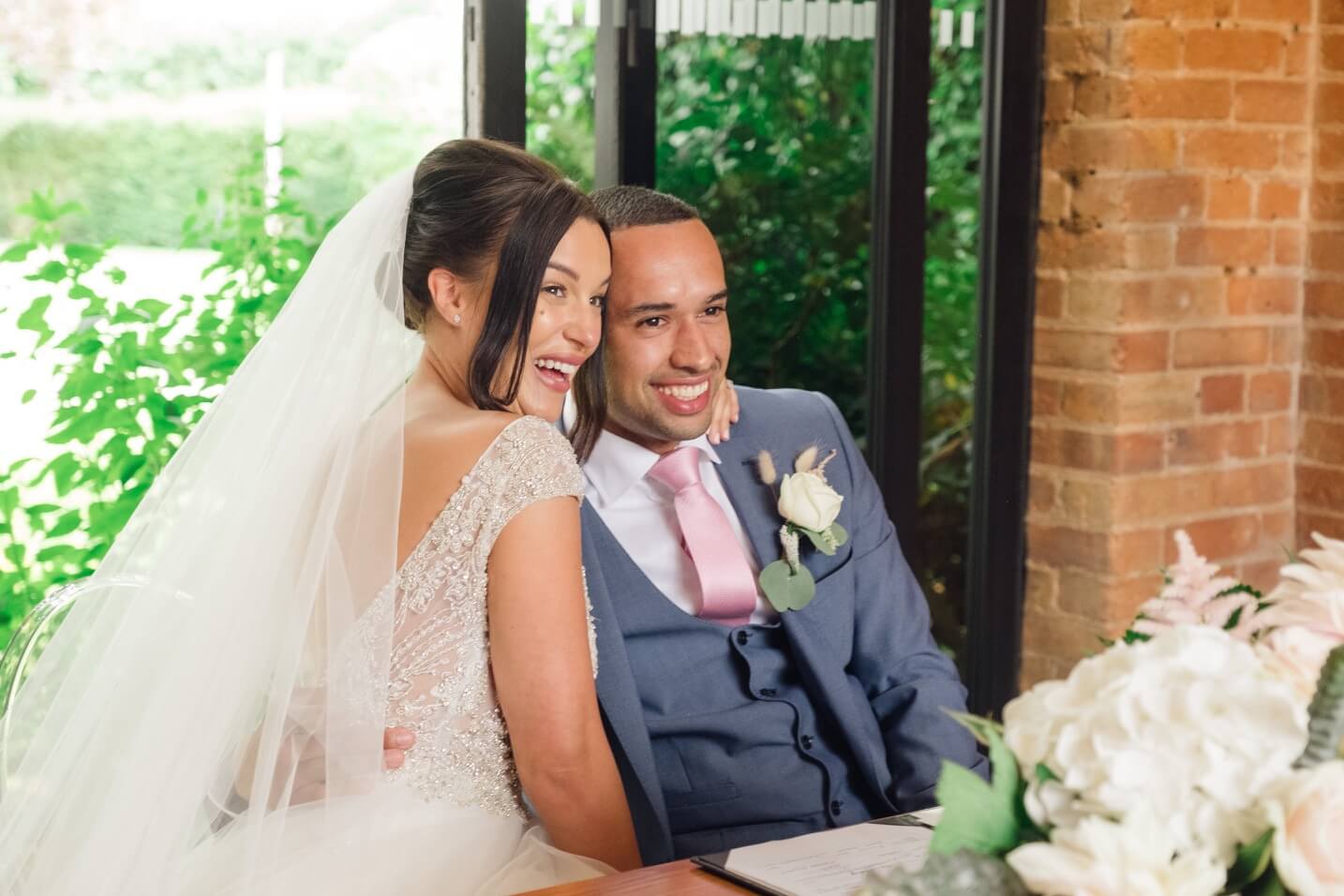 Newlyweds celebrating after signing the register in the redbrick barn