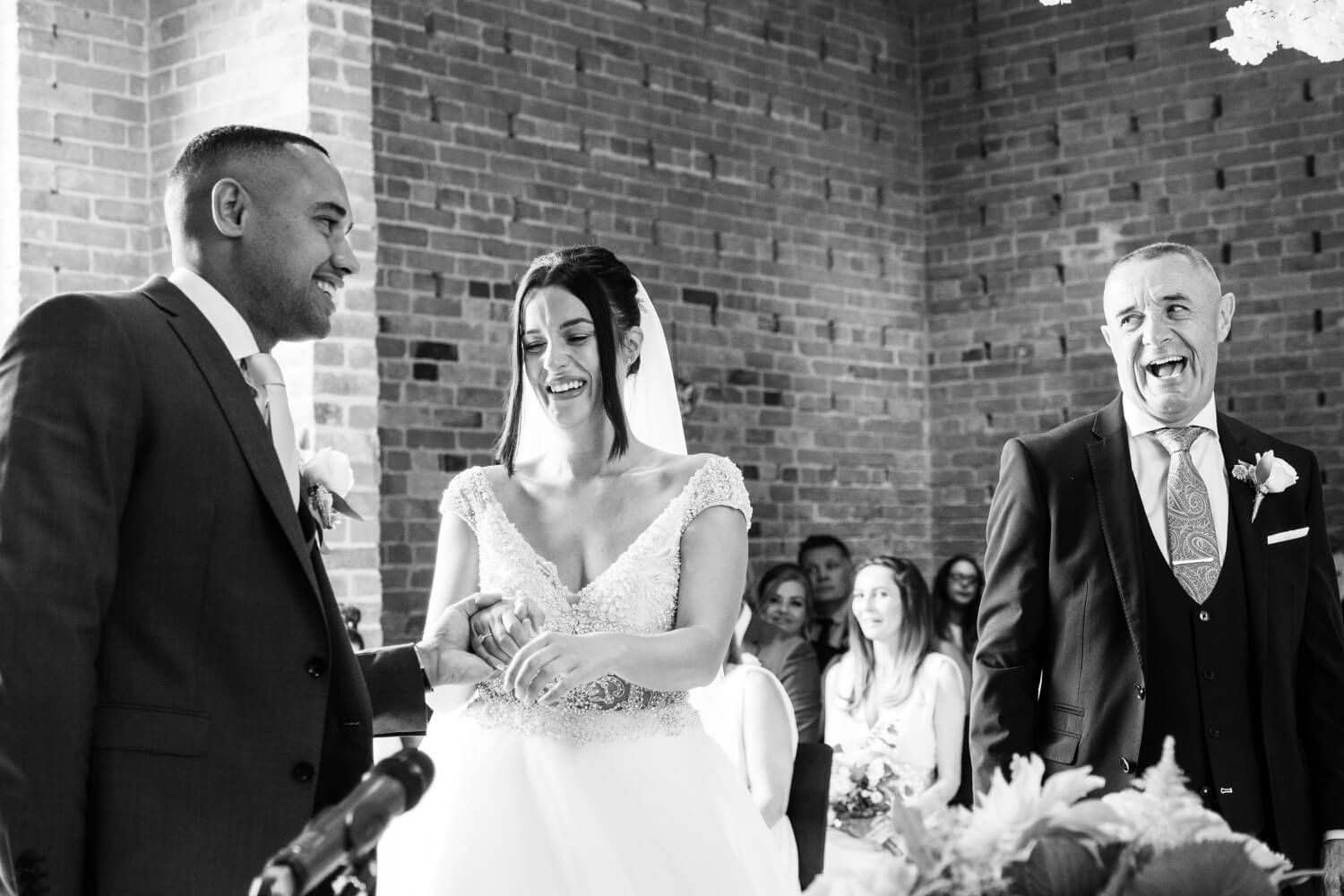 Father of the bride passing his daughter to the groom at a Redhouse Barn wedding ceremony