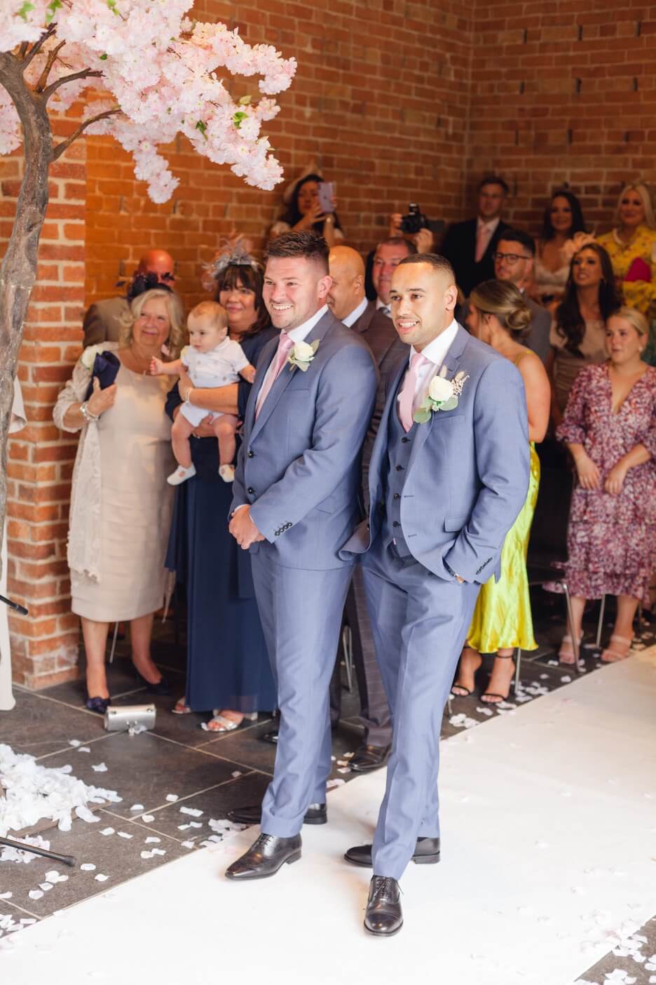Groom waiting for his bride in the redbrick barn at Redhouse Barn