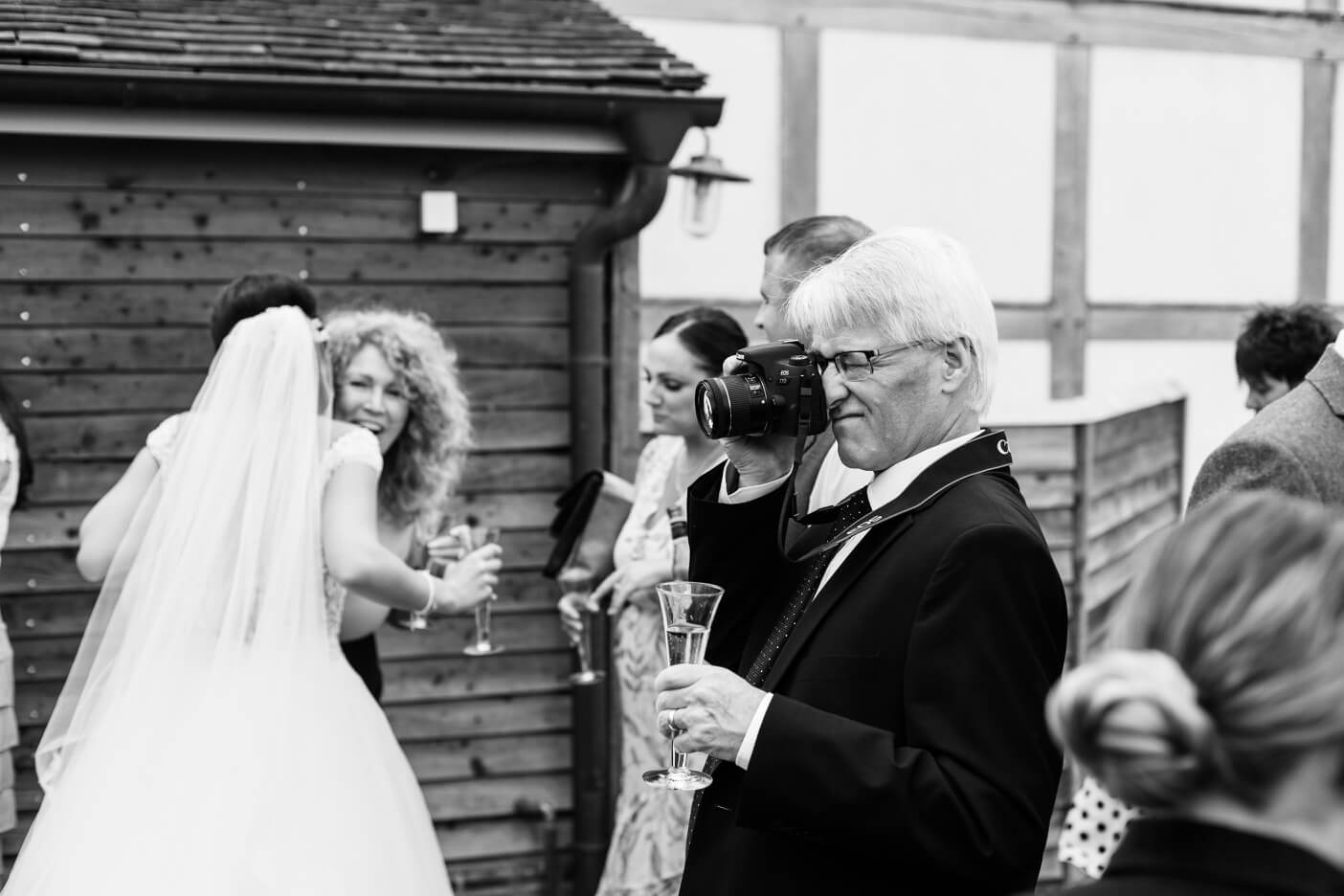 Guest taking photos with a camera in the courtyard at Redhouse Barn
