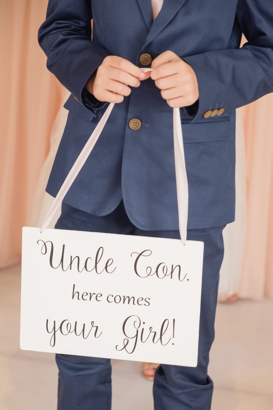 Page boy holding a wedding sign at Redhouse Barn