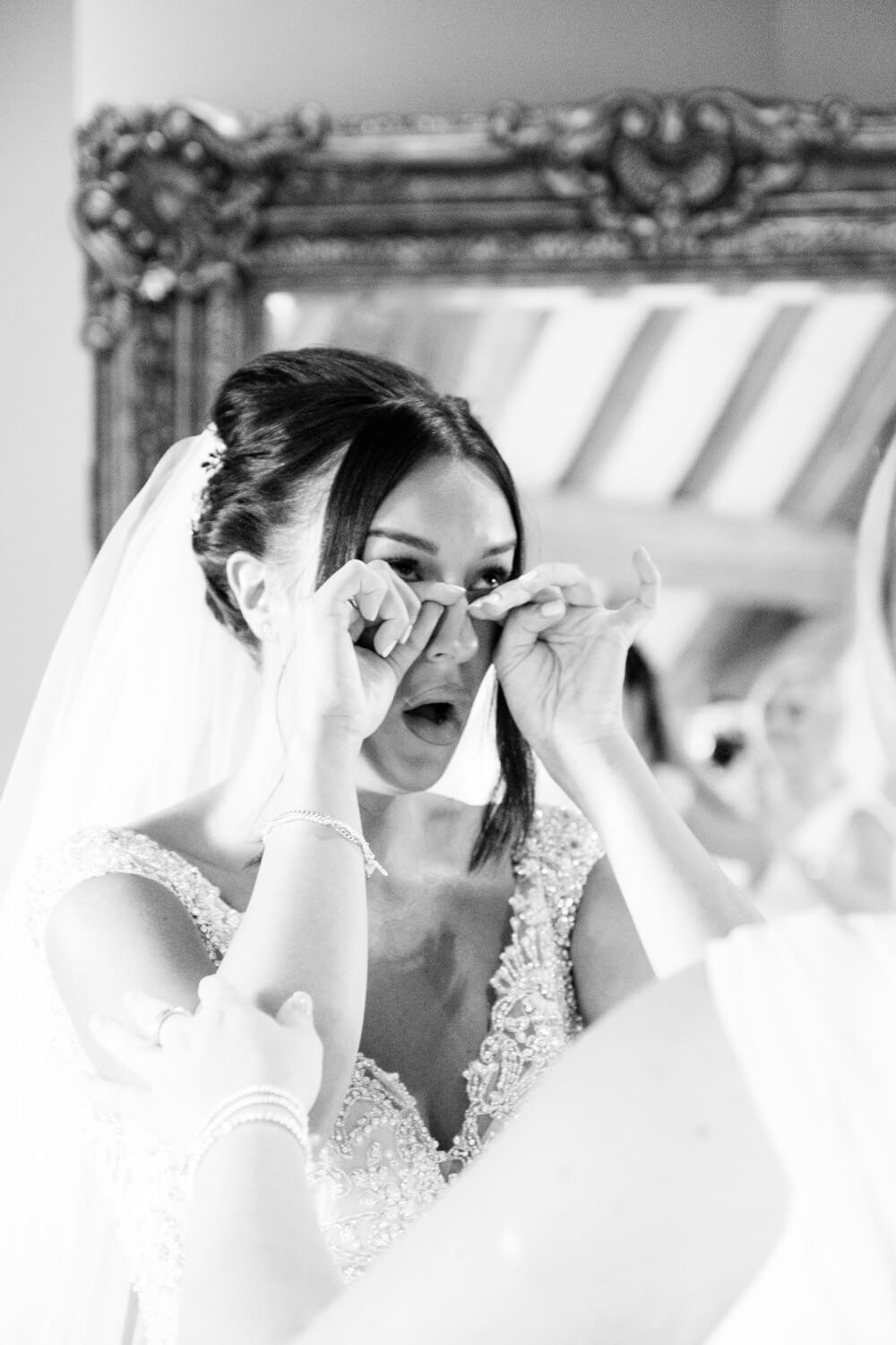 Bride holding back happy tears in the bridal suite at Redhouse Barn
