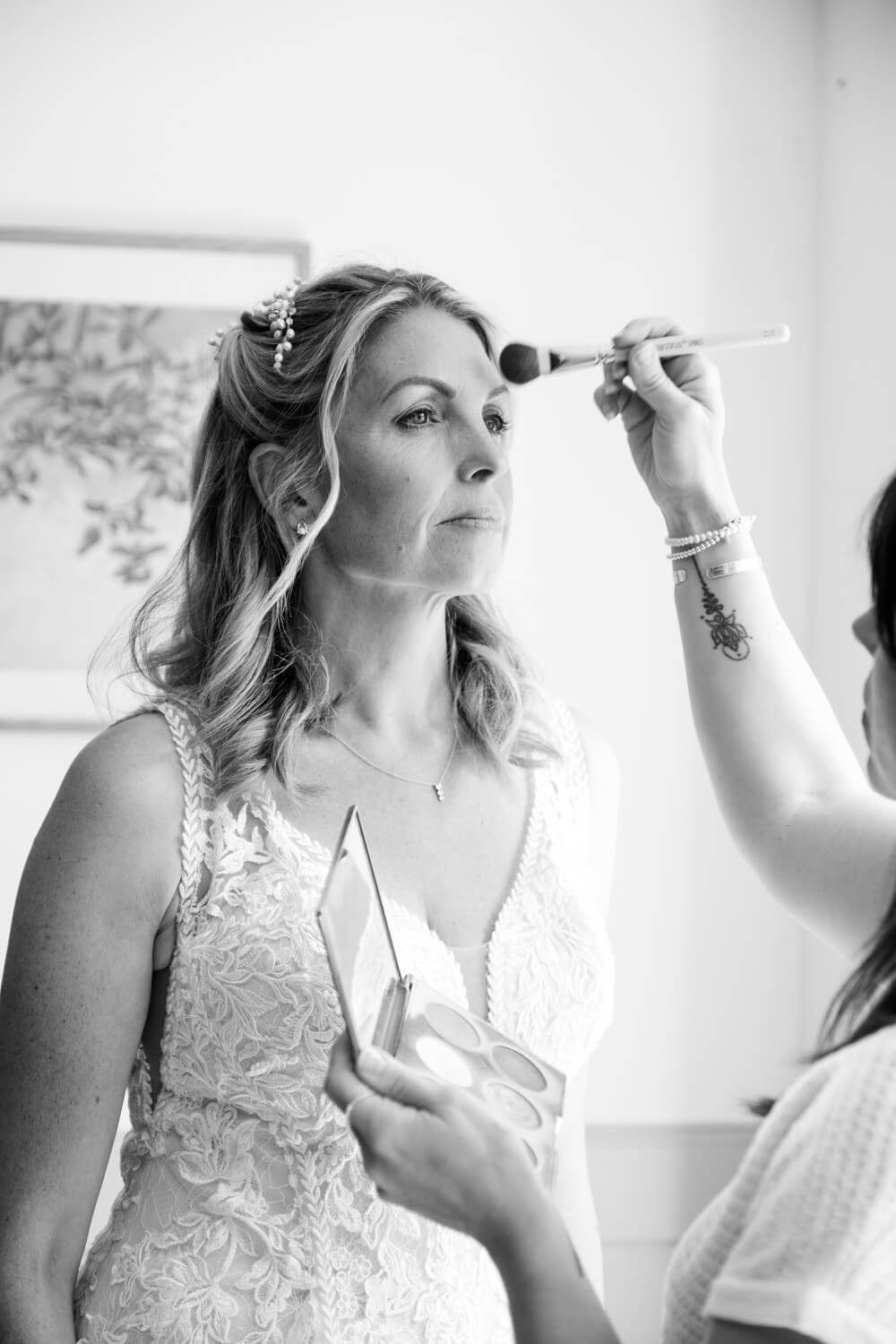 Bride having her makeup finished before leaving for Shustoke Barn